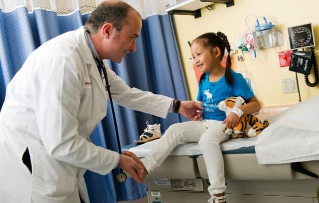 a doctor examines a child with osteoarthritis of the groin